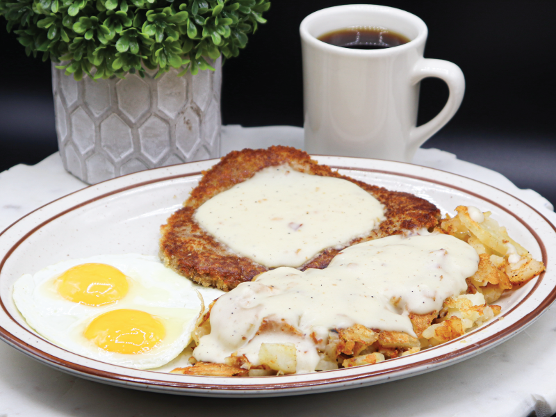 Country fried steak topped with gravy and served with homestyle potatoes and sunny side up eggs at Jack's Cafe.